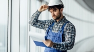 happy-young-man-architect-hard-hat-holding-folder_496169-985